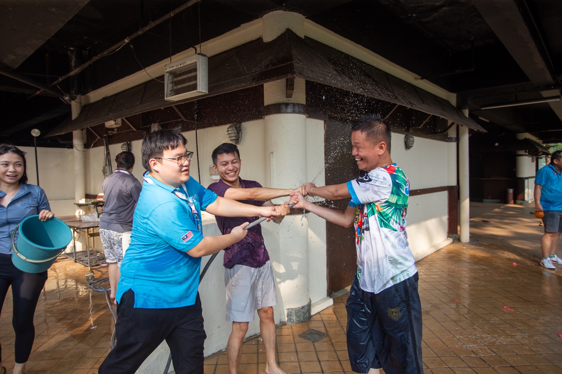 Academians working together with a water hose