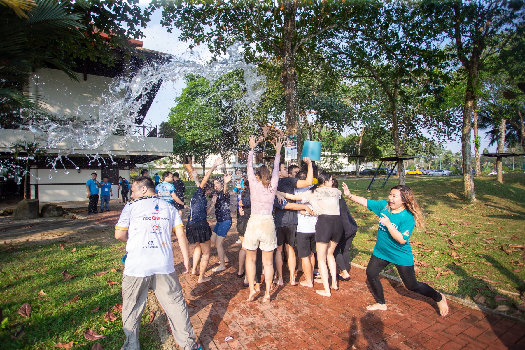 Water flying over Academians during an outdoor team challenge